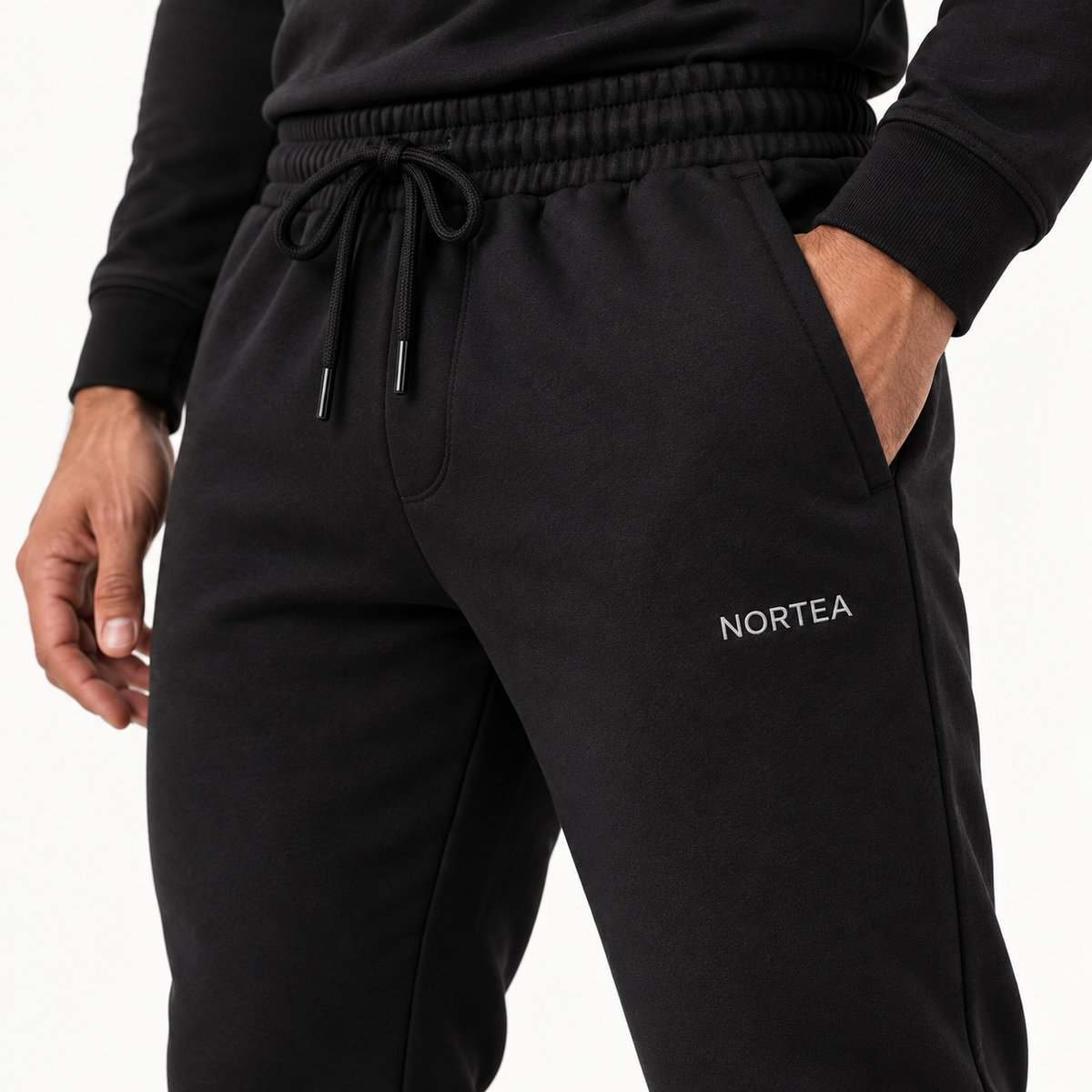 Detalhe da jogger NORTEA preta com cós, cordão, bolso e wordmark frontal